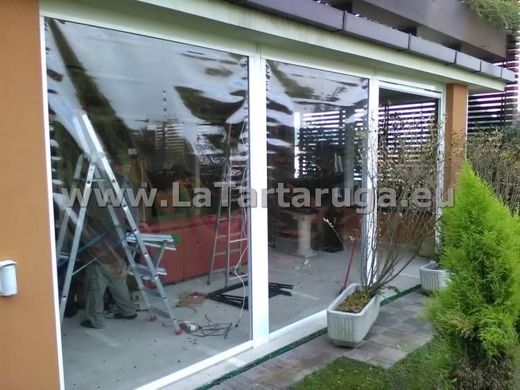 Chiusura di un porticato con tende trasparenti a chiusura ermetica. Motorizzate